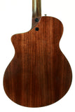 Back view of a wooden acoustic guitar on a white background