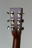 Close-up of a guitar headstock with tuning pegs on a gray background